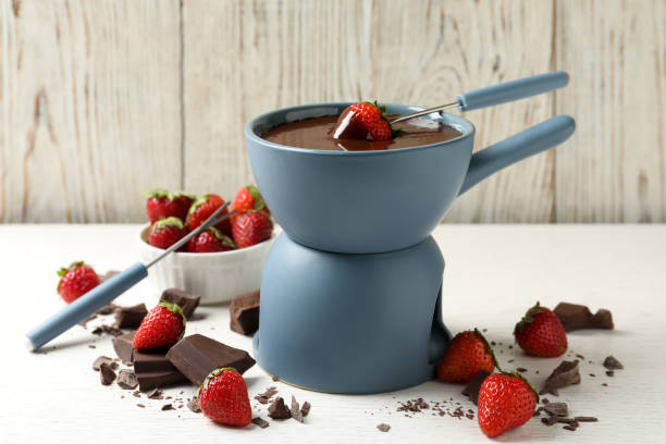 istock Fondue pot with chocolate and fresh strawberries on white table 1356125275