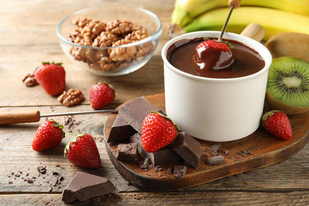 istock Fondue pot with chocolate and different products on wooden table 1356125936