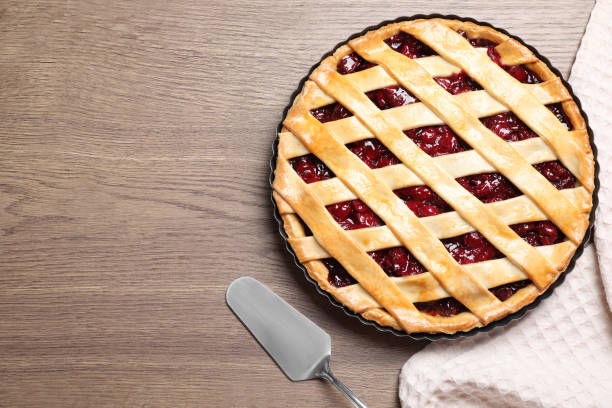 istock Flat lay composition with delicious fresh cherry pie on wooden table. Space for text 1356126140