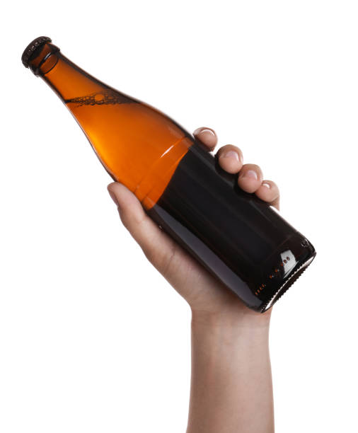 istock Man holding brown bottle with beer on white background, closeup 1356126364