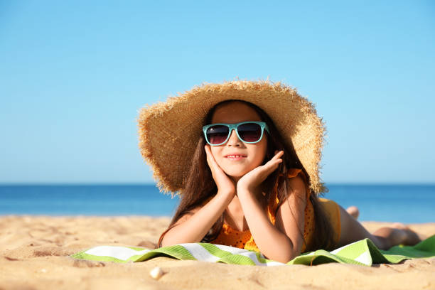 istock Cute little child lying at sandy beach on sunny day 1356126450