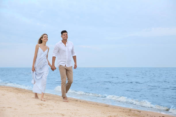 istock Happy couple having romantic walk on beach. Space for text 1356126653