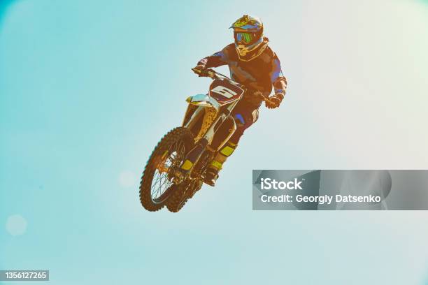 Extreme Sports Motorcycle Jumping Motorcyclist Makes An Extreme Jump Against The Sky Extreme Sports Motorcycle Jumping Motorcyclist Makes An Extreme Jump Against The Sky Special Processing Under The Film With Flare Stock Photo - Download Image Now