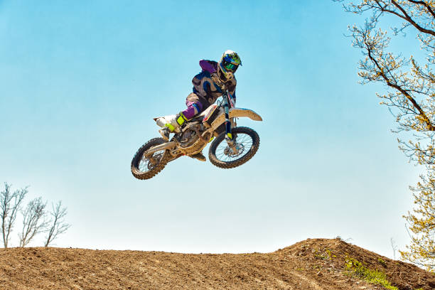 sport estremi, salto in moto. motociclista fa un salto estremo contro il cielo - dirt jumping foto e immagini stock