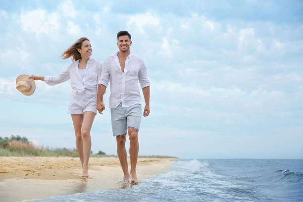 istock Happy couple having romantic walk on beach. Space for text 1356127336