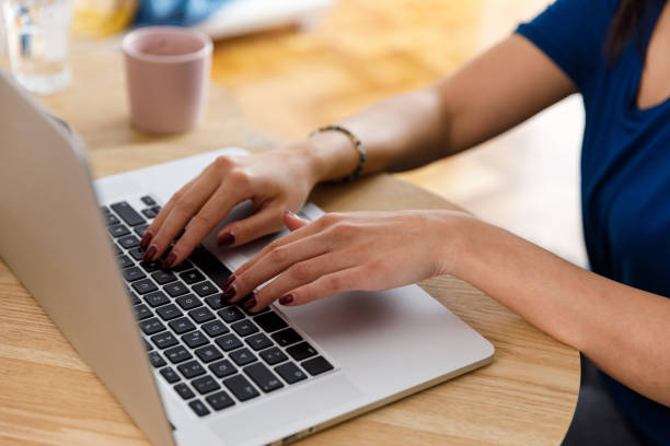 istock Young woman typing emails on laptop while catching up with friends 1356127589