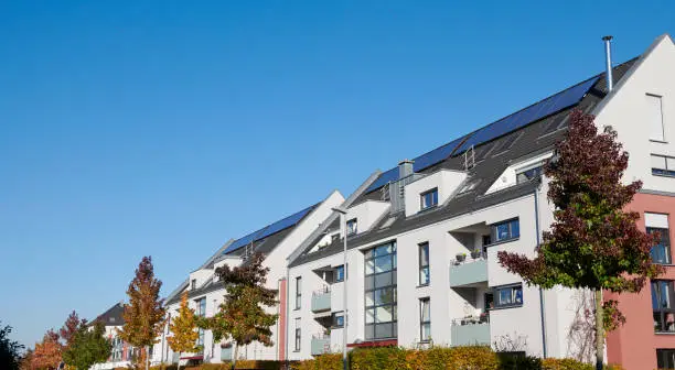 Typical apartment houses with solar panels in autumn. (Germany)