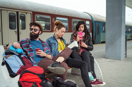 Young travelers wasting time while waiting at the train station