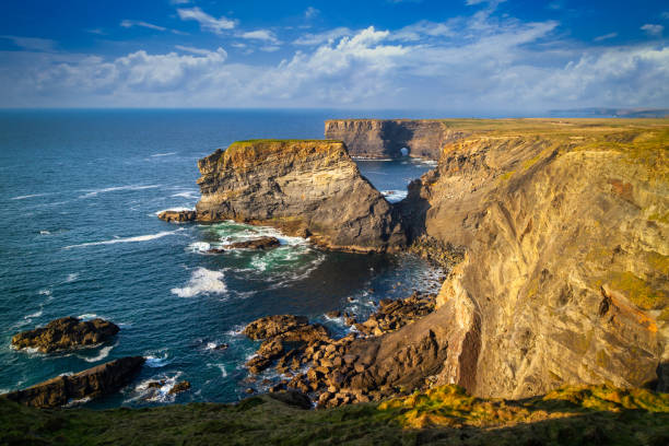 scogliere rocciose a kilkee in una giornata di sole, contea di clare - kilkee foto e immagini stock