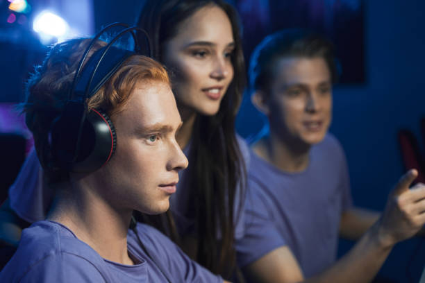 istock Handsome pro gamers playing in online video games on computer and talking with each other 1356129514