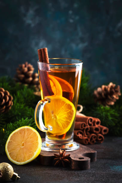 istock Hot winter tea drink, spicy cocktail with lemon, rum, cinnamon, anise. Rustic style, copy space. Christmas table setting 1356131174