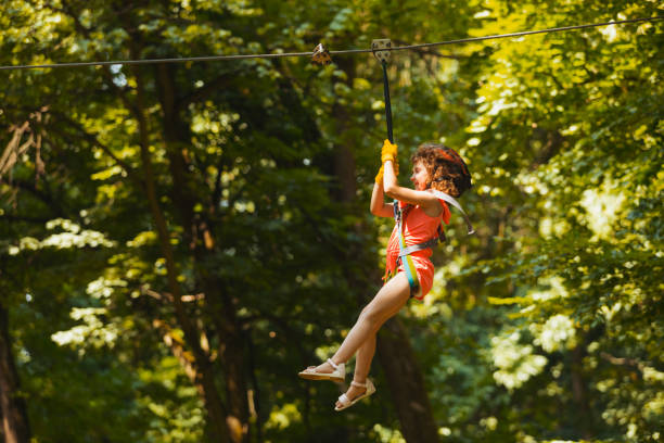 istock Low Angle View Of Man Jumping Hanging On Tree 1356131512
