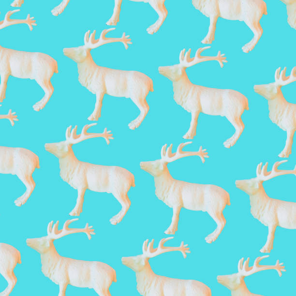 istock Pattern of white reindeers on blue background. Christmas decorations 1356134997