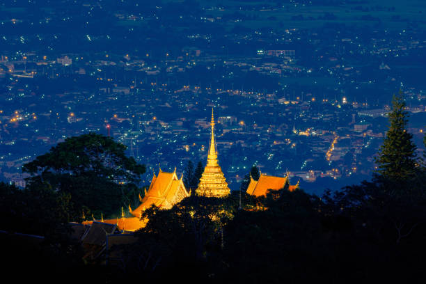 Wat Phra That Doi Suthep, Ratchaworawihan temple pagoda with Chiang Mai Downtown Skyline, Thailand. Financial district in urban city in Asia. Buildings on mountain hill at night. stock photo