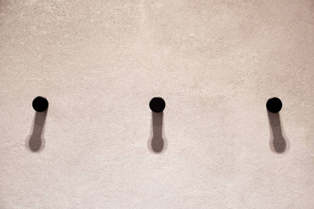 istock Three metallic black hooks on the empty wall in the modern wardrobe 1356137800