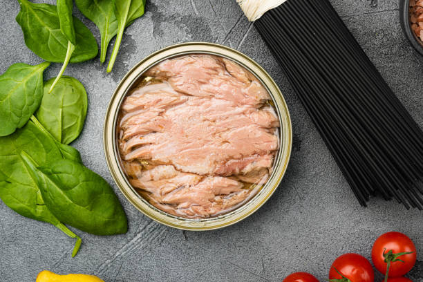 tuna canned fish seafood, on gray stone table background, top view flat lay - tuna chunks imagens e fotografias de stock