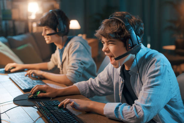giocatori che giocano insieme ai videogiochi online - teenager video game gamer child foto e immagini stock