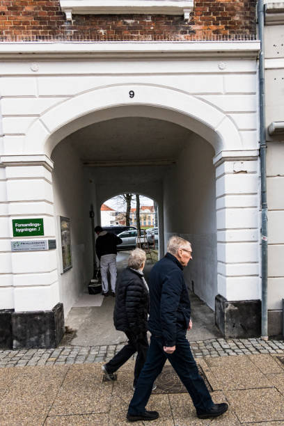 Hjorring, Denmark Hjorring, Denmark Nov 24, 2021 A senior couple walking besides an archway. hjorring stock pictures, royalty-free photos & images