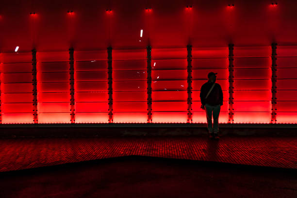 Hjorring, Denmark Hjorring, Denmark Nov 23, 2021  The lit up facade of the local Theatre, the Vendsyssel Teater, and a pedestrian standing. hjorring stock pictures, royalty-free photos & images