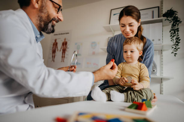 istock Doctor and mother playing with child 1356140192