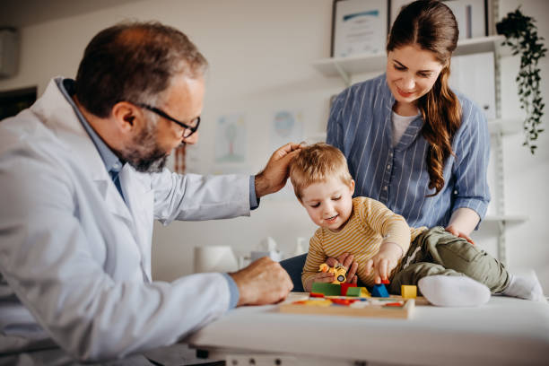 istock Doctor and mother playing with child 1356140353
