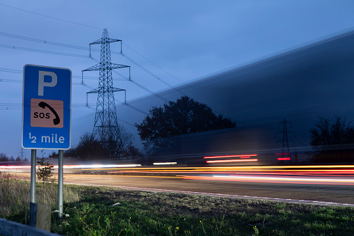 Long exposure of moving traffic viewed by the side of a busy dual carriageway at dusk