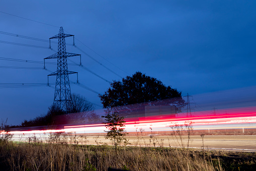 Long exposure of moving traffic viewed by the side of a busy dual carriageway at dusk