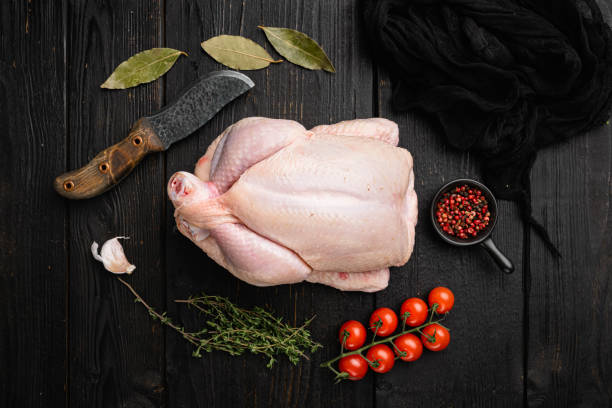 istock Organic raw whole chicken, on black wooden table background, top view flat lay 1356140690