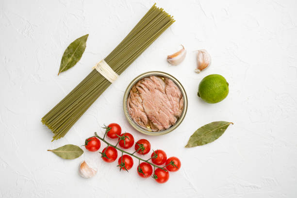 istock Pasta with tuna raw ingredients, on white stone table background, top view flat lay 1356143524
