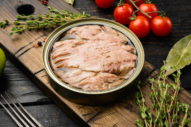 istock Open tuna tin, on black wooden table background 1356144281