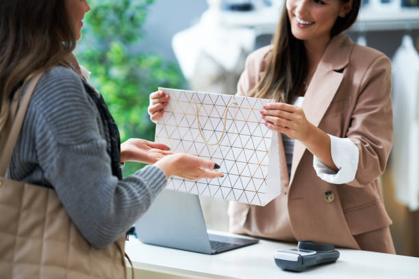 istock Cashier and buyer in cloth store during transaction 1356146355