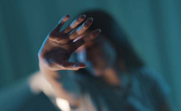 mujer joven haciendo una señal de alto con la mano - violencia fotografías e imágenes de stock