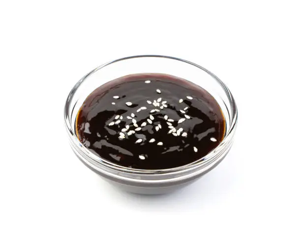 Teriyaki sauce with sesame seeds isolated on a white background. Side view.