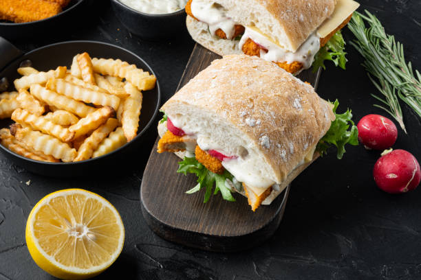 istock Sandwich with Fish Sticks, on wooden cutting board, on black background 1356151716