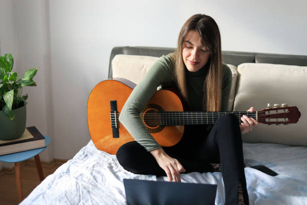 istock Young woman playing guitar. 1356151936
