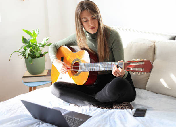 istock Young woman playing guitar. 1356152029