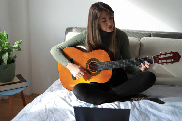 istock Young woman playing guitar. 1356152030