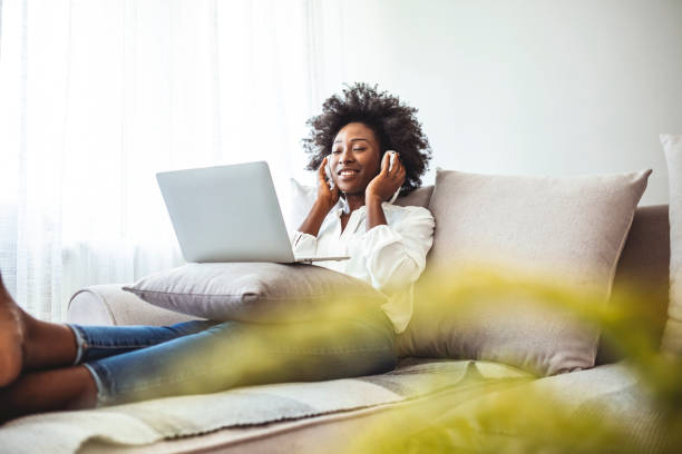 istock Young woman enjoying at home using laptop. 1356152229