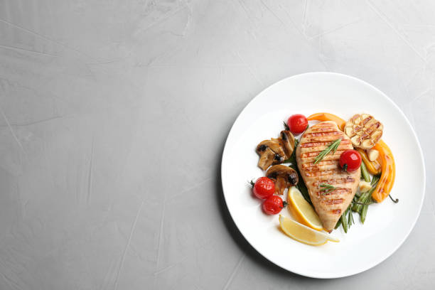 istock Tasty grilled chicken fillet with vegetables on light grey table, top view. Space for text 1356155443