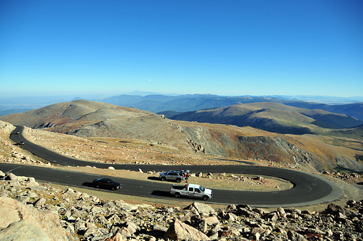 Mount Evans, Clear Creek County, Front Range of the Rocky Mountains, Colorado, USA: cars go down a switchback curve on Mount Evans Scenic Byway. The road begins in Idaho Springs at the I-70, using State Highway 103 and continues on State Highway 5 to the summit of Mount Evans. The Scenic Byway climbs more than 2,000 meters from its starting point and is the highest paved road in the United States (4,307 meters at the top).