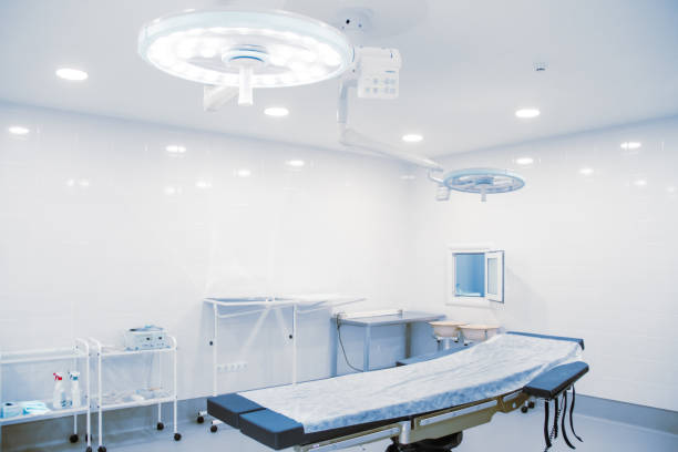 istock Empty operating room in a hospital. Surgical equipment with operating table. Medical device for emergency patient in blue tone style. Blank Emergency Surgery Room. Clinic interior for background 1356156358