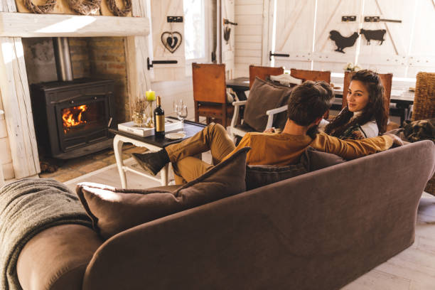 istock Happy couple chatting on the sofa during a romantic getaway in a cozy, rustic cabin 1356157066