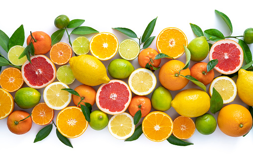 Ripe oranges with halves and slices with orange tree leaves randomly fall or levitate on a white background. Juicy background for your project. Clipping path.