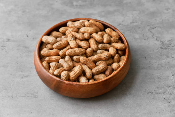 istock Image of bunch of peanuts in a bowl on a concrete surface 1356158495