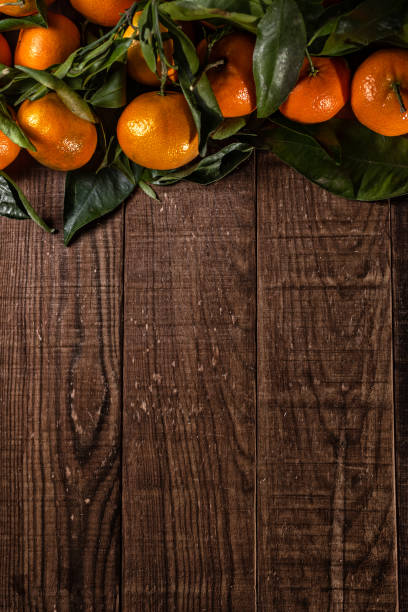 istock Tangerines with leaves on rustic wood with copy space. 1356160711