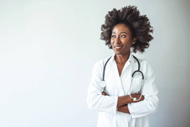 istock Woman hospital worker looking at camera and smiling, studio, grey background 1356161279