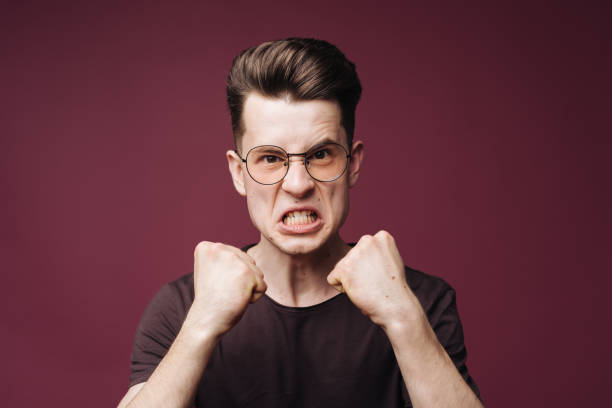 emotional man in white t-shirt studio dissatisfaction red background. High quality photo