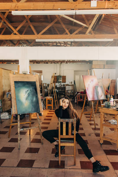 istock Confident female artist sitting in her workshop 1356161392