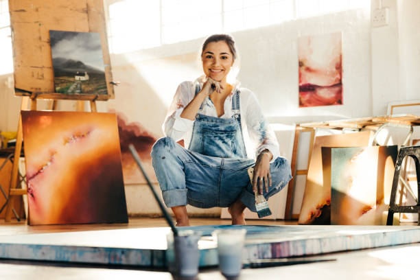 istock Carefree female painter working in her art studio 1356162277