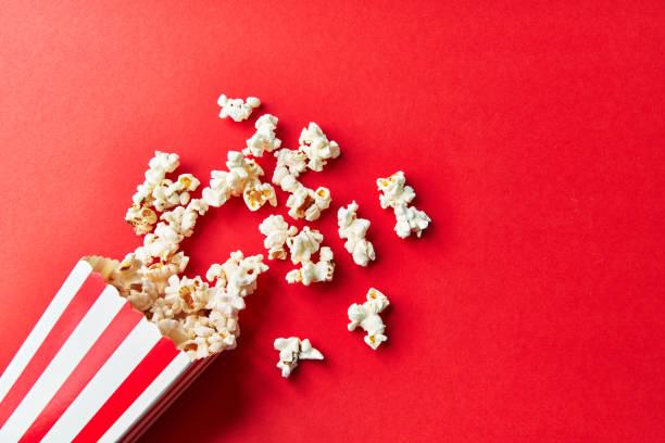 istock Pack of salty popcorns falling on a red background 1356162744